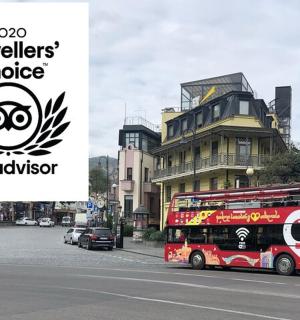 a red double decker bus on a city street