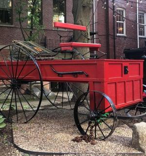 一辆红色手推车停在一栋建筑物前