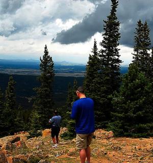 eine Gruppe von Menschen steht auf einem Berggipfel