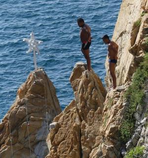 Dva muži stojí na skalách poblíž oceánu
