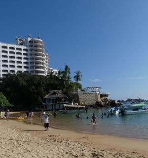 lidé na pláži s loděmi ve vodě