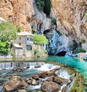 a river with a building on the side of a mountain