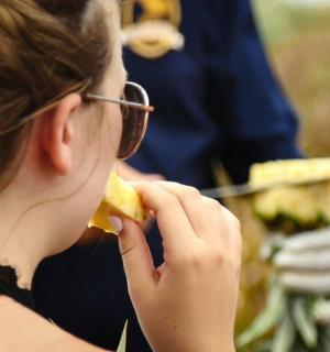a woman with glasses eating a piece of food