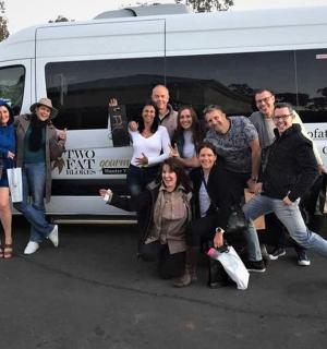 hópur fólks stendur fyrir framan sendibíl