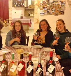 a group of women sitting around a table with wine glasses