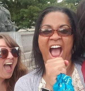 two women with their mouths open in front of a statue