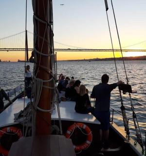 一群人在水中的船上，有一座桥