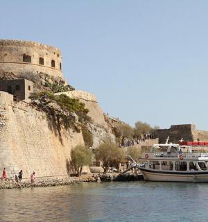 loď ve vodě vedle hradu