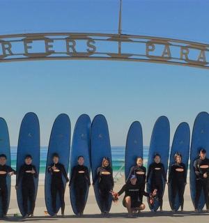 a group of people standing in front of surfboards