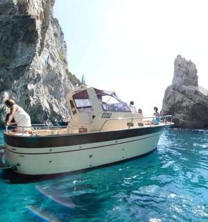 loď ve vodě vedle skalního útvaru