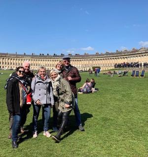 a group of people standing in the grass in front of a building