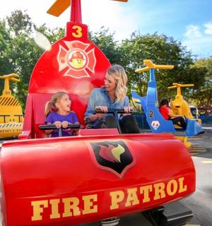 žena a dítě na hasičské jízdě na horské dráze