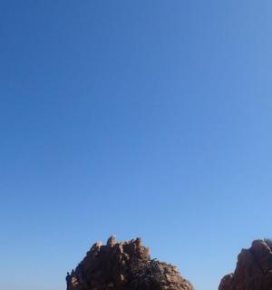 dva lidé stojící na vrcholu skal