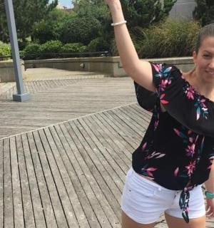 žena stojící na promenádě s rukou ve vzduchu