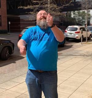 a man standing on a sidewalk talking on a cell phone