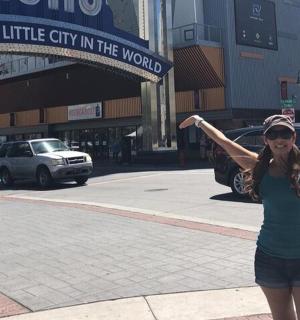a woman standing on a street with her arms in the air