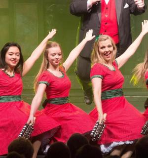 skupina dívek v červených šatech na pódiu