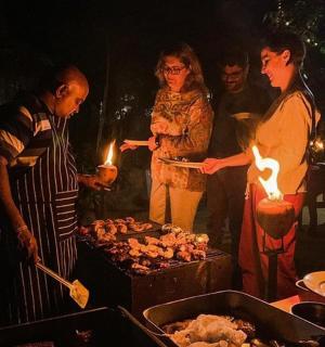 a group of people standing around a grill with lights