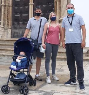 三个戴着面具的人站在一栋建筑物前