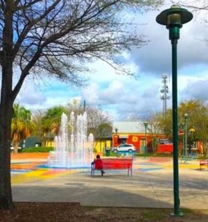 a fountain in a park with a red bench and a street light