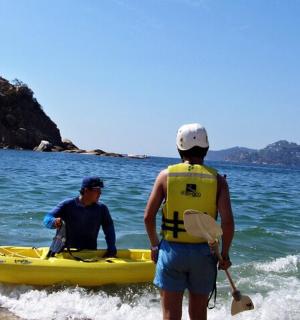 two men in a yellow kayak in the water