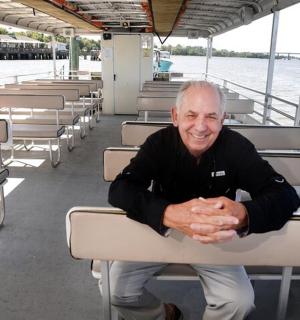 an older man sitting in a chair on a boat