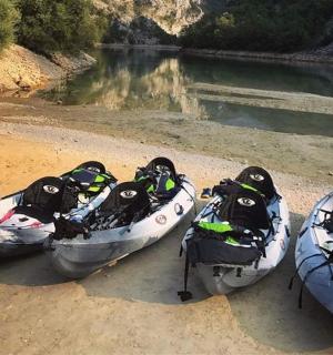 tři kánoe sedící na břehu řeky