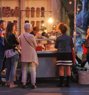 skupina lidí stojících kolem pojízdného stánku s jídlem