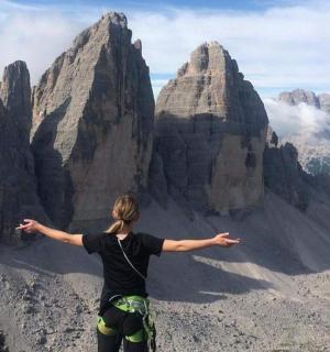 一位女士站在山顶上，张开双臂