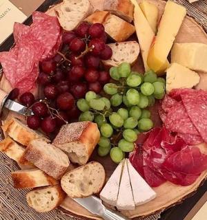 a plate of food with grapes and meats and cheese