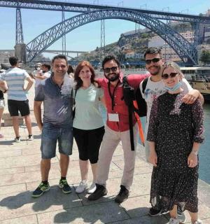 a group of people posing in front of a bridge