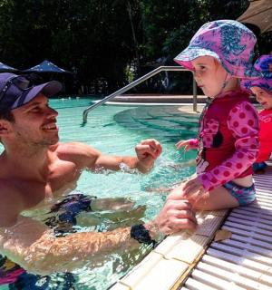 一名男子和一个小女孩在游泳池里