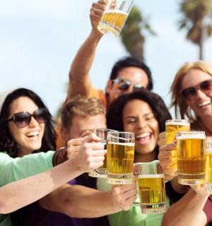 a group of people holding up glasses of beer