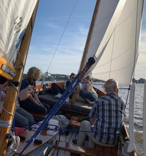 a group of people on a sail boat on the water