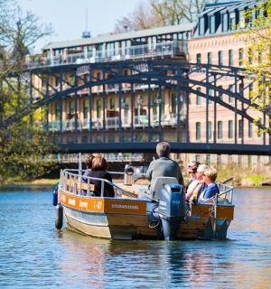 eine Gruppe von Menschen in einem kleinen Boot auf einem Fluss