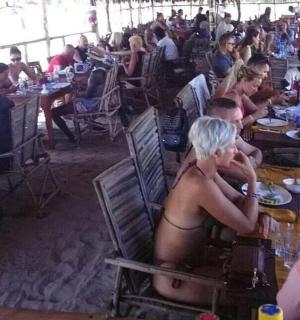 a group of people sitting at tables in a restaurant