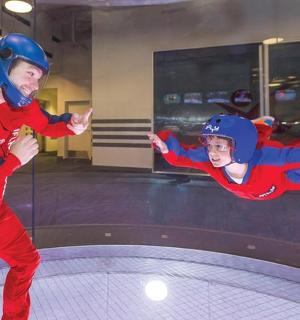 Muž a chlapec v červeném skáčou na trampolíně