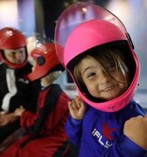 一个戴着头盔并竖起大拇指的孩子