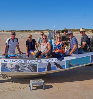 一群人坐在沙滩上的船上