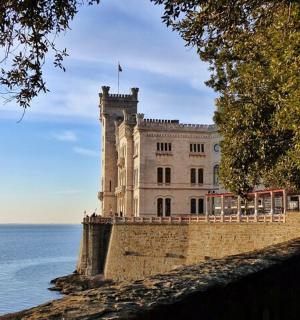 budova s vlajkou na vrcholu vedle vody