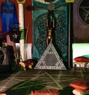 a room with a altar with a pyramid and pillows