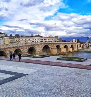 a bridge over a river with two people walking