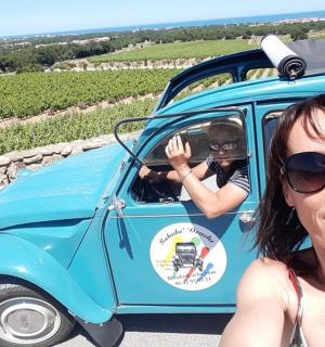 a woman standing next to a small blue car with a man