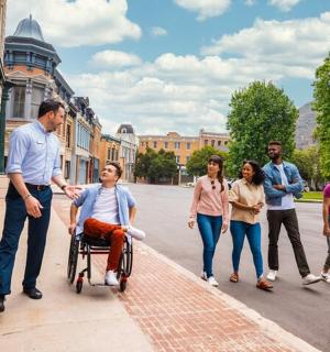 一群人和一个坐在轮椅上的男子一起走在街上