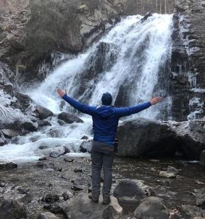a man standing in front of a waterfall
