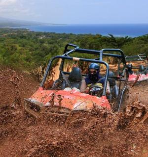 skupina lidí jedoucích na čtyřkolce na prašném kopci