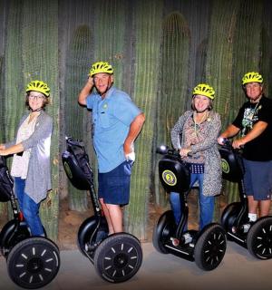 a group of four people wearing helmets on segways