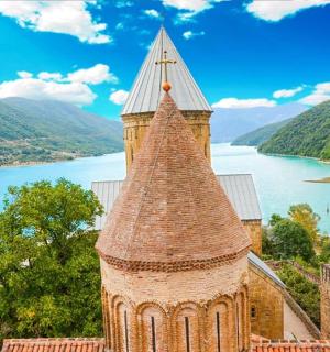 a building with a tower next to a body of water