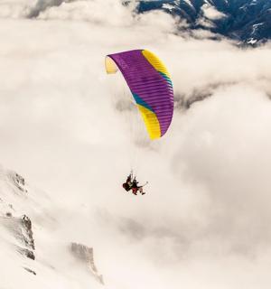a person flying in the air with a parachute