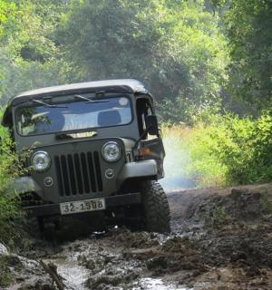 a jeep driving down a muddy dirt road